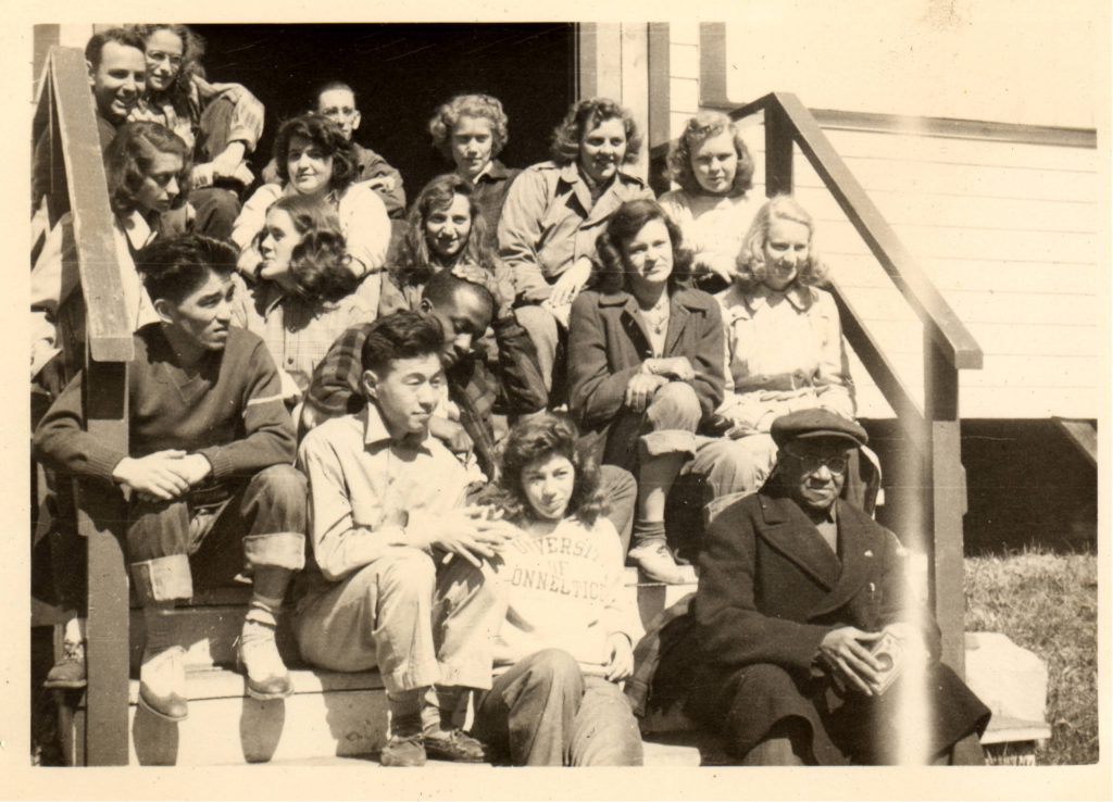 Satt, Jeanette, and group at UConn sitting on a staircase. The photo is in black and white