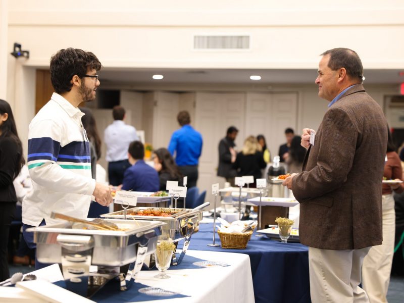 Two people having a conversation over a buffet station