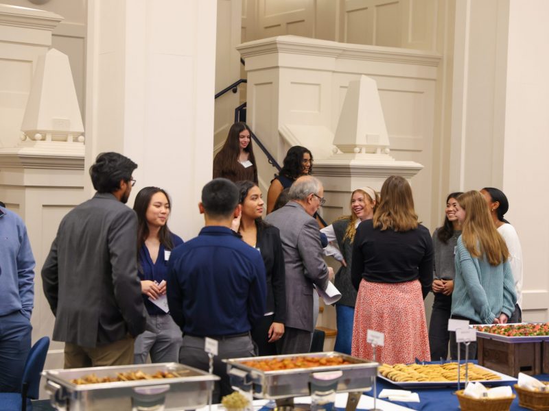 A group of people networking at the Great Hall at the Alumni Center