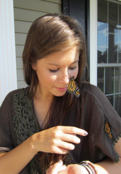 Alexandra Frey with a monarch butterfly landing on her nose