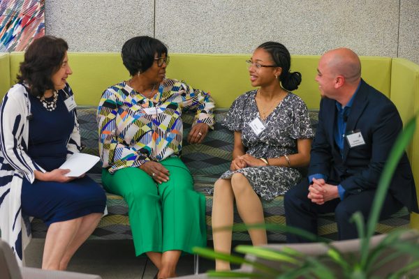Four people sitting on a couch and talking at a financial literacy innovation program event