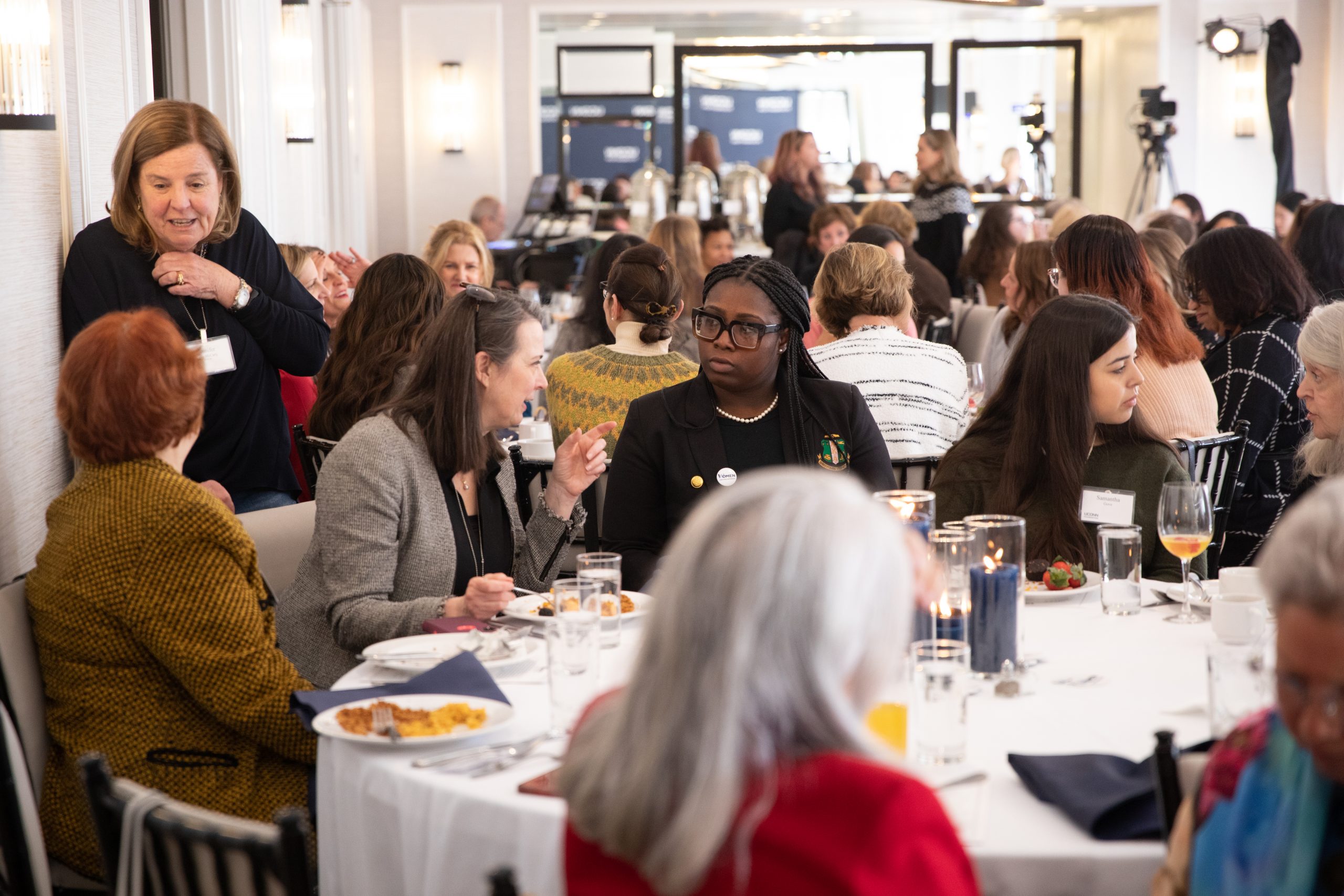 Women talking to each other at tables during the Women and Philanthropy Brunch at the Goodwin Hotel