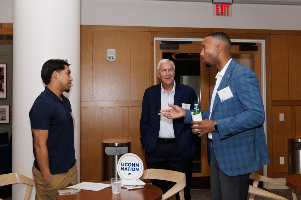 Three people talking and wearing professional attire at the Hartford Promise Networking event