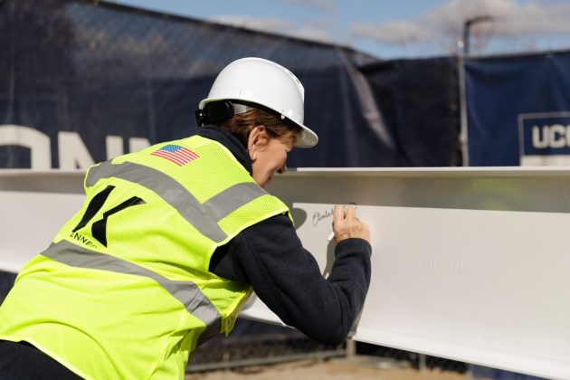 Elisabeth DeLuca signing the beam on October 27, 2025.