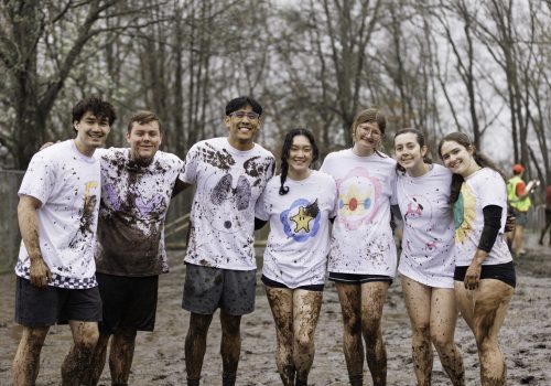OOzeball 2025 Students posing for a photo at the Oozeball event, with mud on their clothes