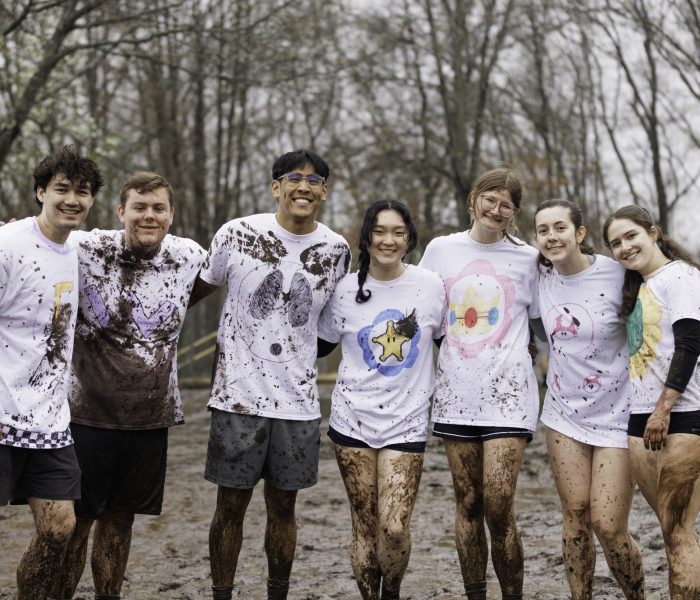 OOzeball 2025 Students posing for a photo at the Oozeball event, with mud on their clothes