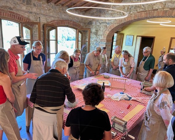 Flavors of Tuscany Cooking Class People at a cooking class in a stone building during the "Flavors of Tuscany" travel trip