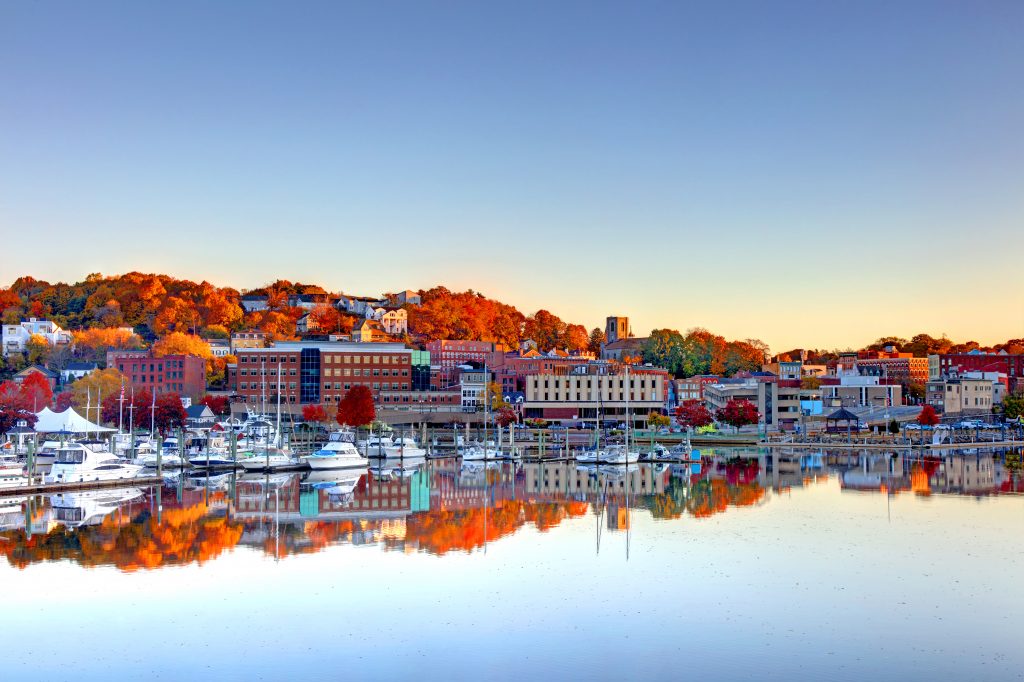 The town of Norwich on a lake with autumn trees in the background