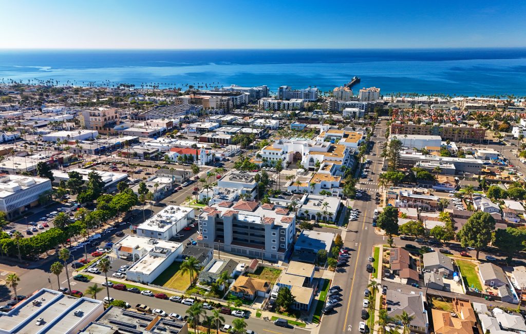 Aerial of Oceanside, CA, a suburb of San Diego, with a view of the Pacific Ocean and a clear blue sky in the background